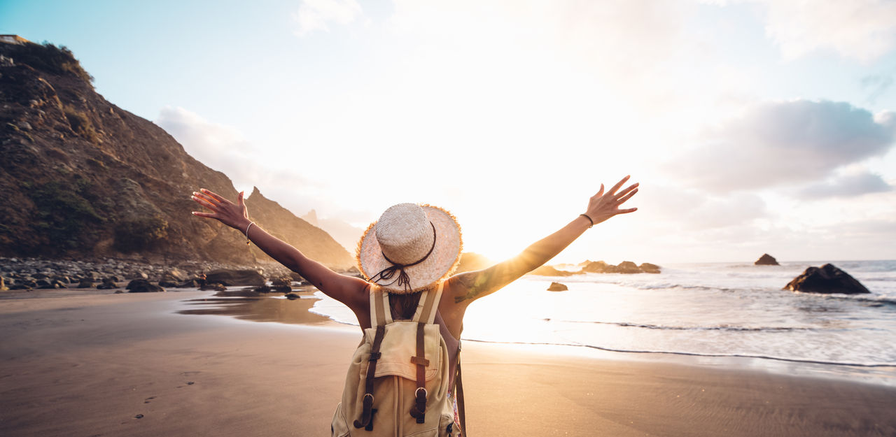 Happy woman with arms up enjoy freedom at the beach at sunset. Wellness, success, freedom and travel concept,Happy woman with arms up enjoy freedom at the beach at sunset. W