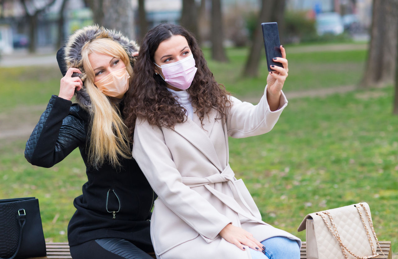 Two young women in the city wearing masks and gloves during corona virus pandemic,Two young women in the city wearing masks and gloves during coro