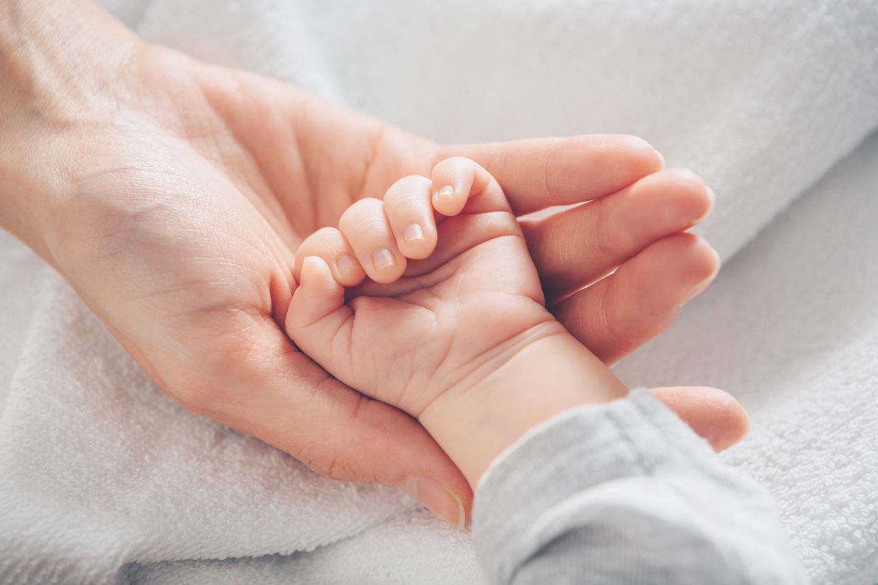 lose-up baby hand on mother's hands