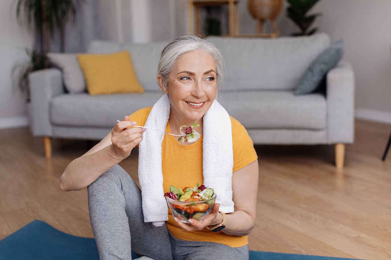 Ältere Frau nach Sport isst Salat