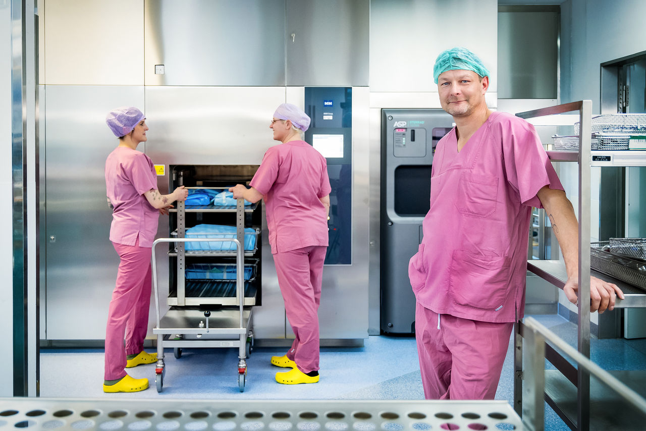 Leiter der Aufbereitungseinheit für Medizinprodukte, André Fink, mit Mitarbeiterinnen bei der Beladung der neuen Sterilisatoren 