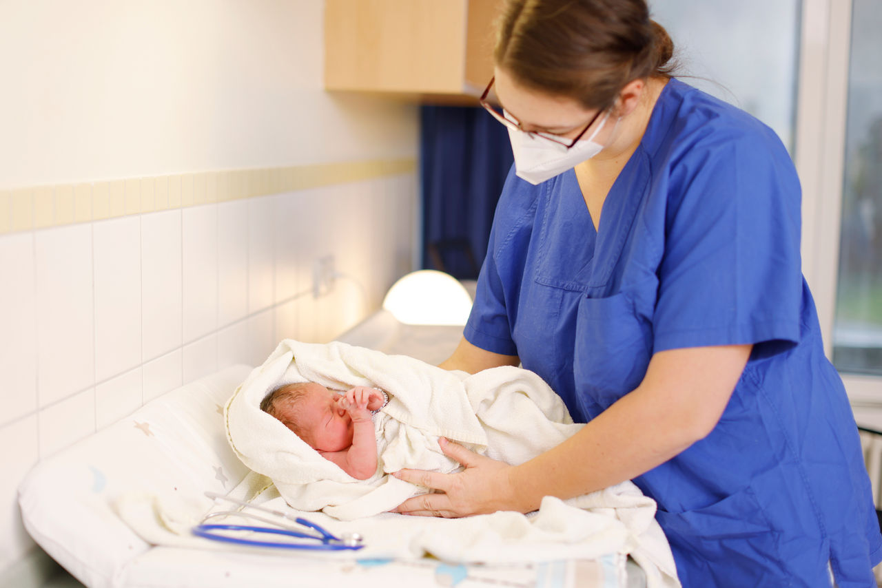 Geburtshilfe: Hebamme mit Neugeborenem