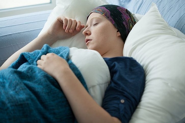 Krebskranke Frau schläft auf Sofa