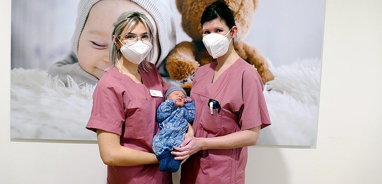 Hebamme Fredericke und Gesundheits- und Krankenpflegerin Angelique heißen Neujahrsbaby Fritz herzlich willkommen 