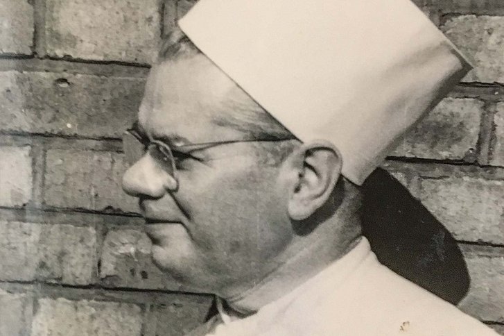 Schwarz-Weiß-Foto eines Mannes mit Kochmütze und Brille