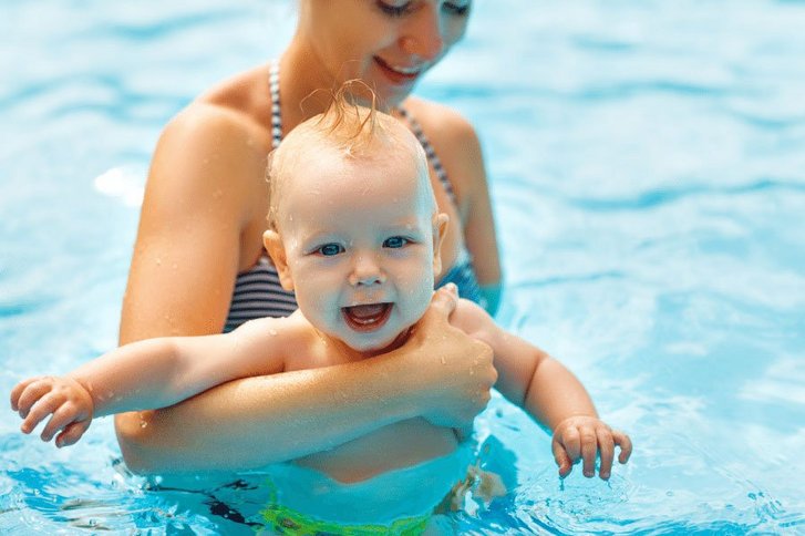Eine Mutter mit ihrem Baby im Schwimmbecken. 