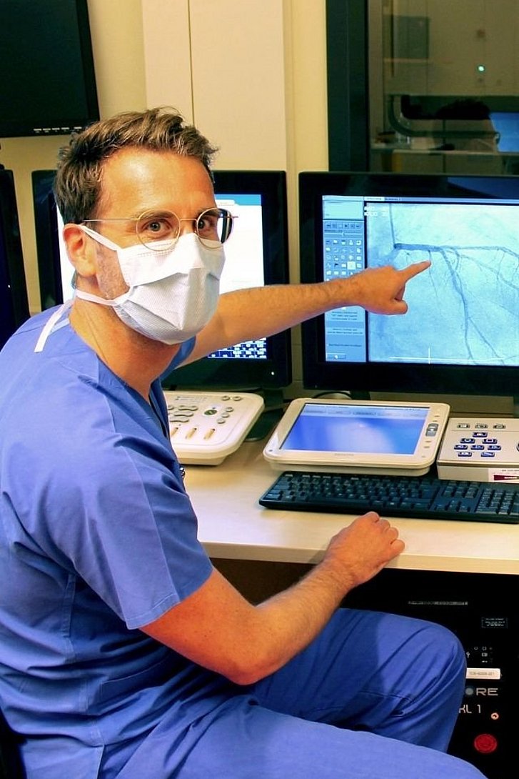 Arzt vor Bildschirm mit Herzgefäßen