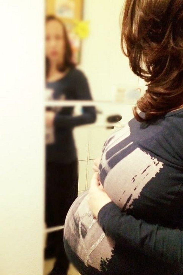 Schwangere Frau vor Spiegel