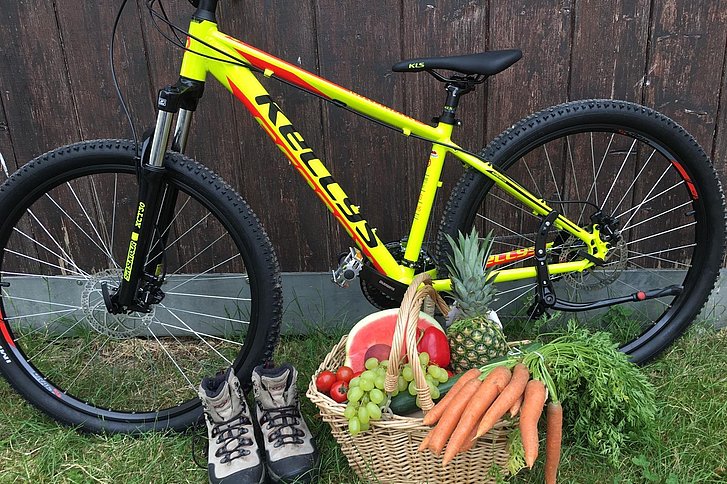 Mountainbike und Gemüsekorb als Sinnbild für Sport und ausgewogene Ernährung