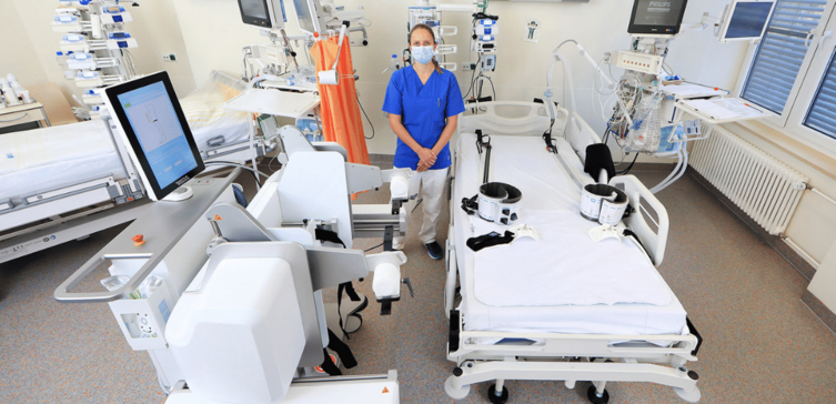 Ein Patientenzimmer ist modern ausgestattet. Man sieht eine Pflegekraft und einen Roboter.