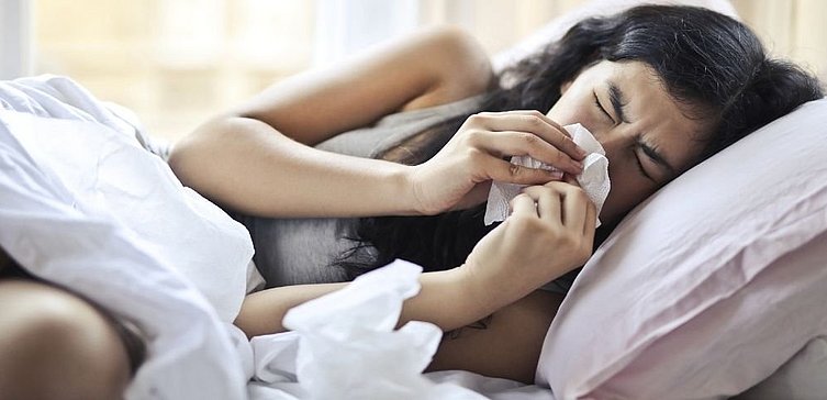 Frau mit Grippe im Bett