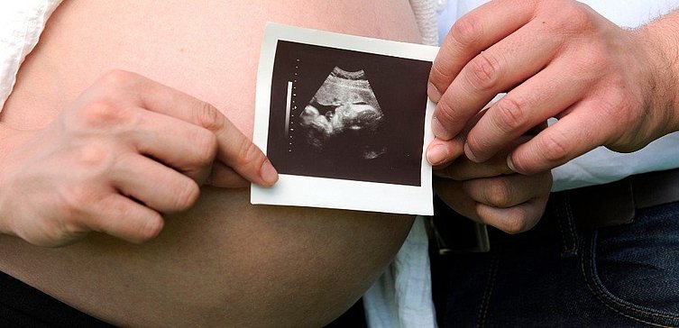 Mann und Frau halten Ultraschall vom Baby in den Händen