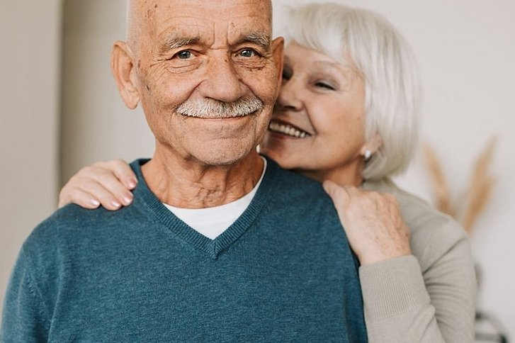 Ältere Frau umarmt älteren Mann
