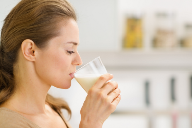 Eine Frau trinkt aus einem Glas Milch