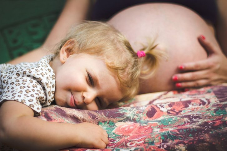Bauch einer Schwangeren, mit kleinen Jungen der kuschelt
