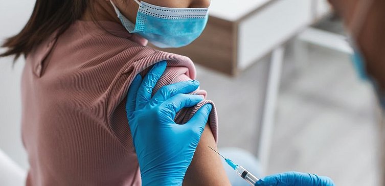 Frau erhält Impfung in Oberarm