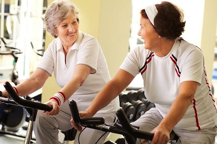 Zwei ältere Frauen auf Fitnessbikes