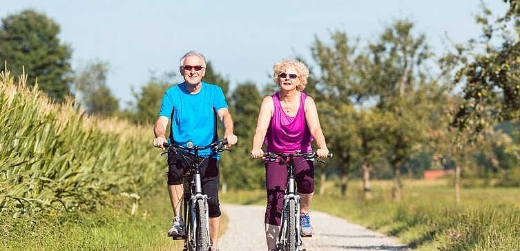 Älterer Mann und Frau fahren Rad 