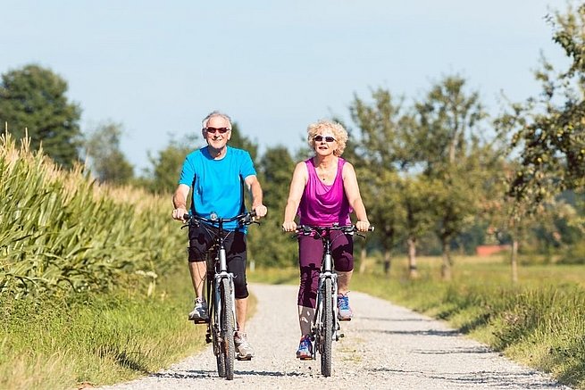 Älterer Mann und Frau fahren Rad