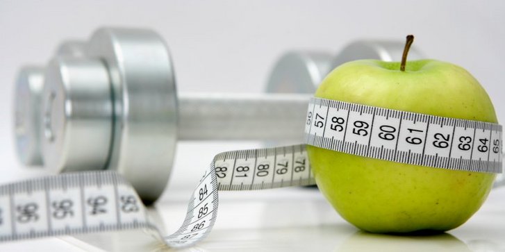 Hantel und Apfel - Sinnbild für Bewegung und gesunde Ernährung