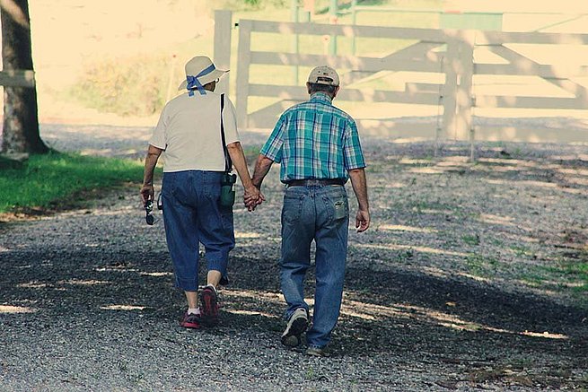 Älteres Paar geht Händchenhaltend spazieren
