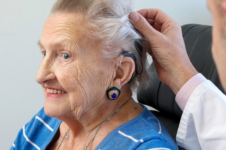 Ältere Dame mit Hörimplantat von der Seite