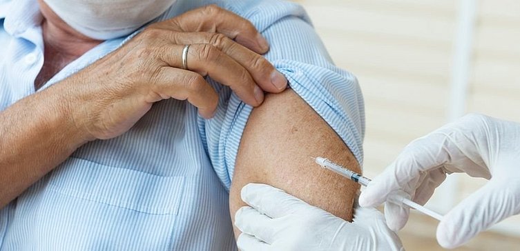 Ältere Dame erhält Impfung in Oberarm