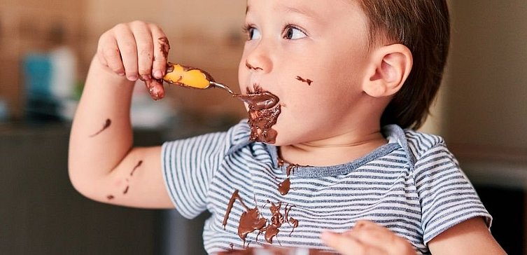 Kleiner Junge isst Schokolade