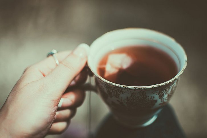 Frauenhand hält eine Tasse Tee