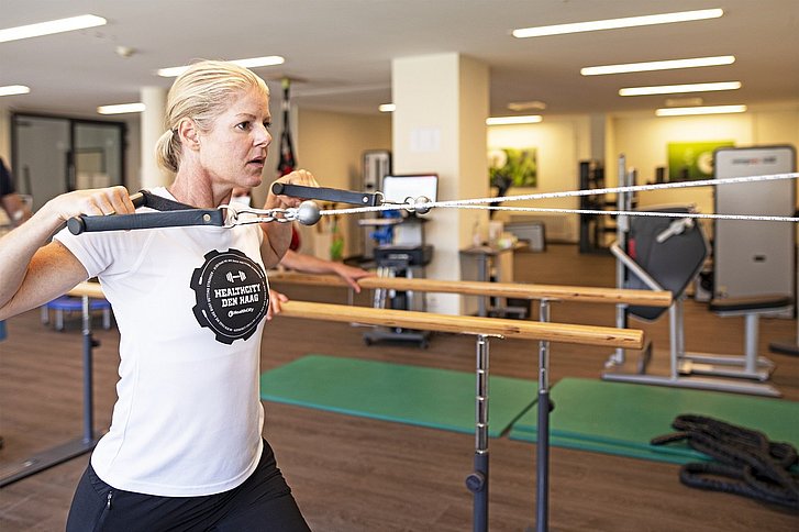 Frau trainiert mit Physiotherapeut