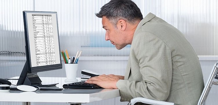 Mann sitzt gebeugt vor PC