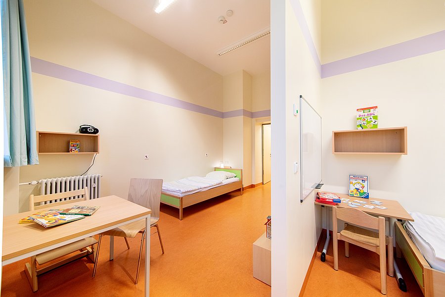Ein voll ausgestattetes Kinderzimmer auf der Station KJP4 mit einem Bett und einem Schreibtisch.